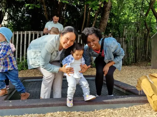 Dos mujeres a principios de sus 30 divirtiéndose juntas y jugando con un niño pequeño. Mostrando amistad y apoyo.